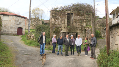 Casa en ruínas e veciños de Corvelle, na Peroxa