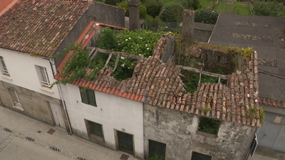 Imaxe deste xoves da casa invadida pola maleza pegada a outra habitada na rúa Santiago de Padrón