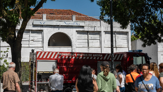 Os bombeiros e veciños ante a antiga escola