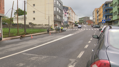 Imaxe da rúa principal de Baio este martes en que operarios municipais traballan na limpeza da lama que deixou a treboada