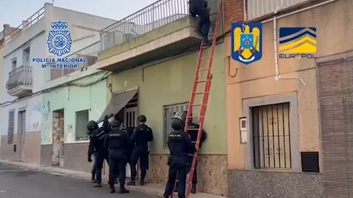 Policía Nacional española e Policía Nacional romanesa entrando nun dos edificios onde se levaba a cabo a actividade (EFE)