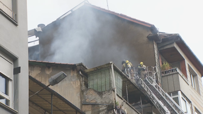 Os bombeiros actúan no tellado do edificio afectado polo incendio en Ourense