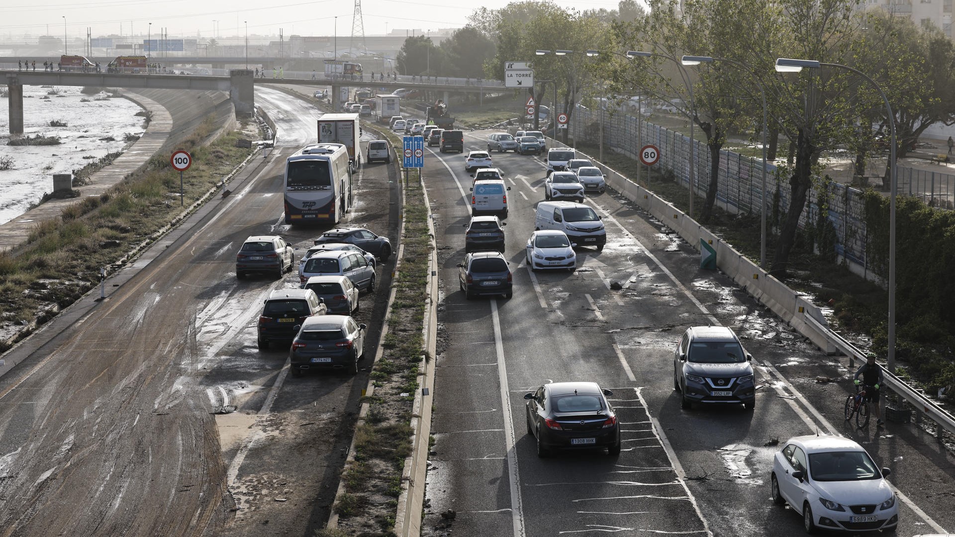 Varios coches circulan entre os vehículos afectados pola DINA na V-30 á altura de La Torre en Valencia (EFE/Biel Aliño)