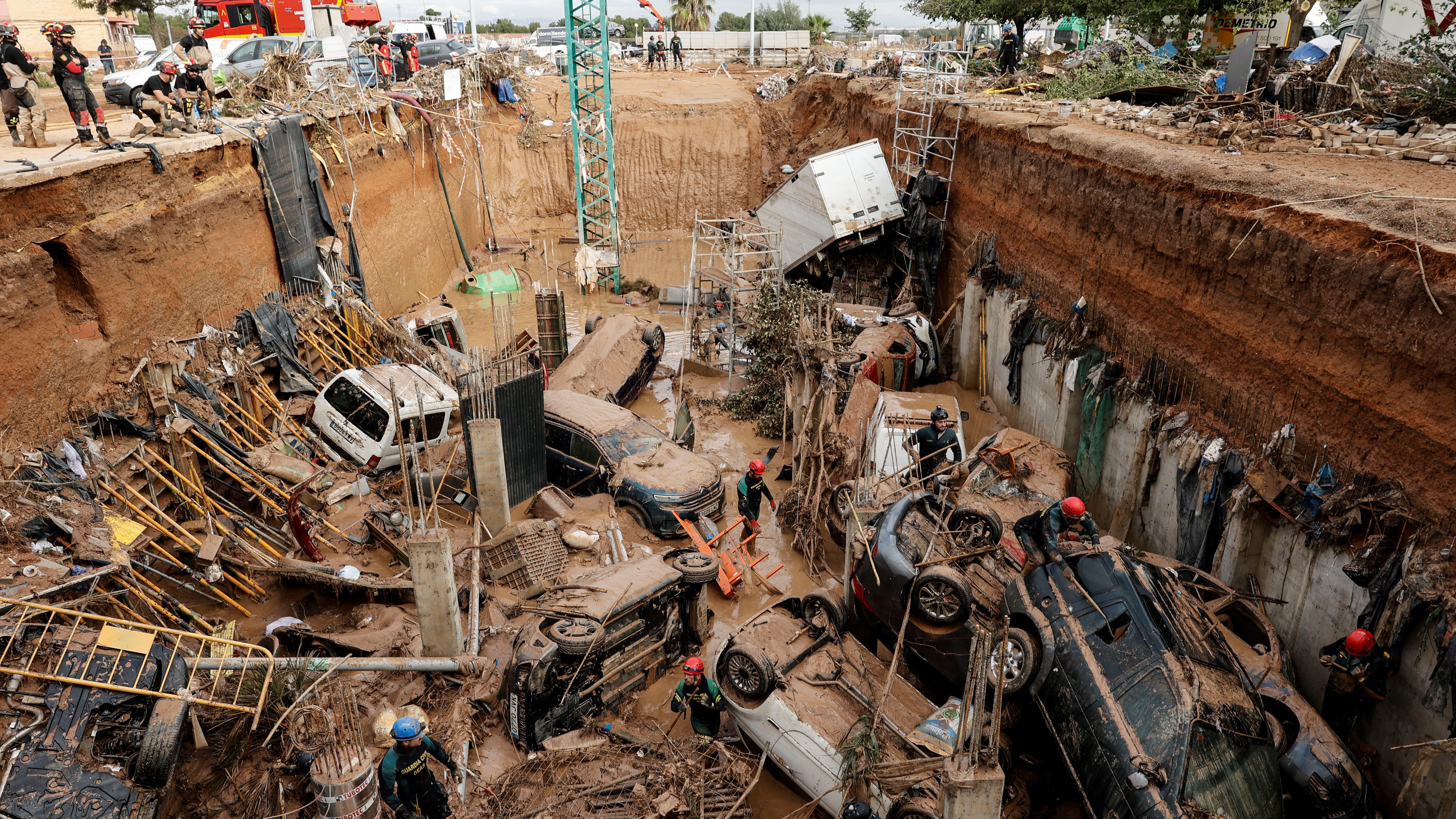 Vehículos no buraco dunha obra en Paiporta. EFE/Biel Aliño