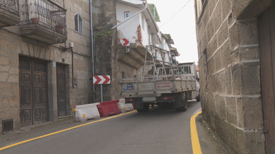 Un camión, alleo aos feitos, pasa por un estreitamento en San Cibrao das Viñas