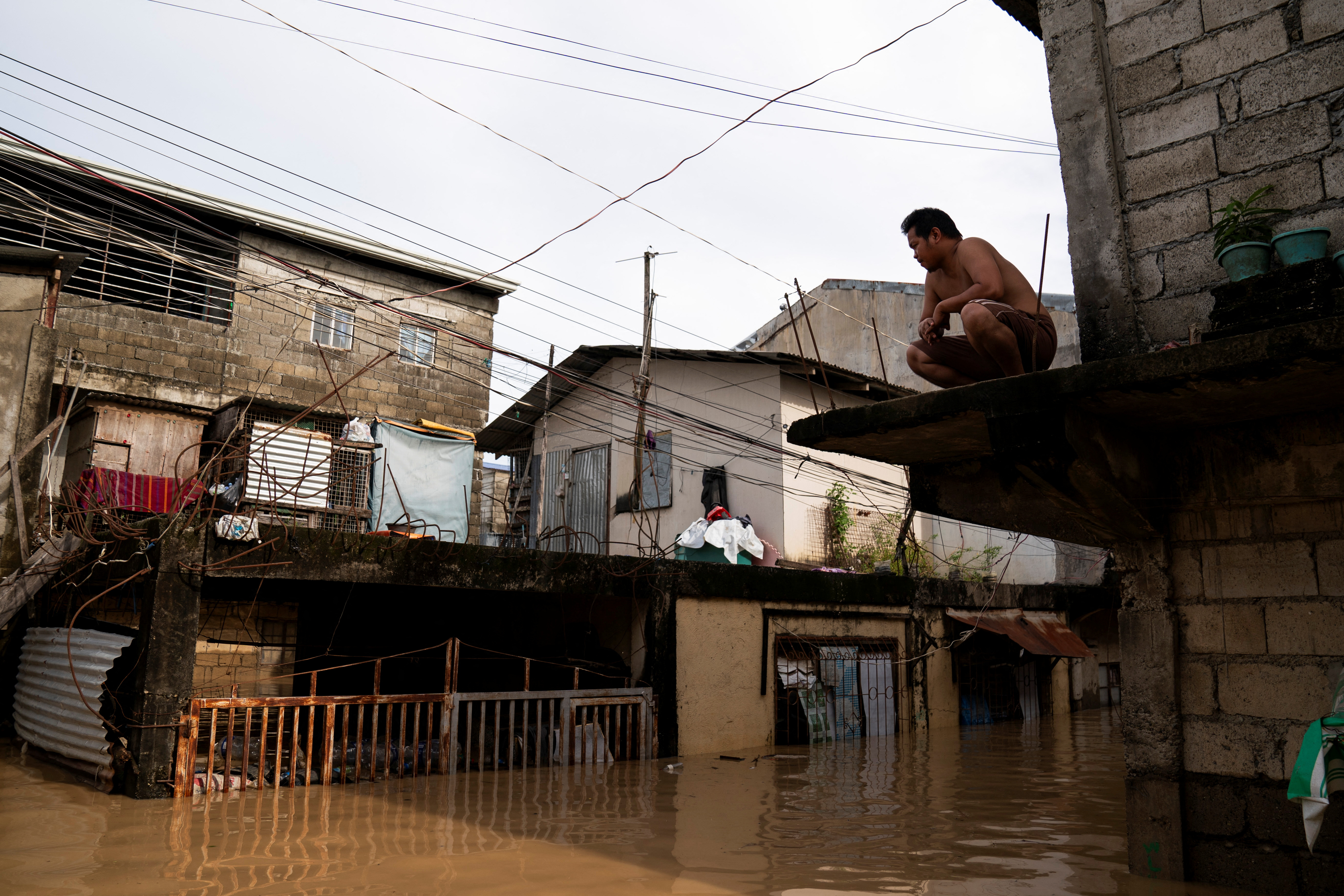 Un home senta nunha repisa fóra da súa casa asolagada despois do tifón Man-Yi, en Cabanatuan, Nova Ecija, Filipinas, 18 de novembro de 2024. REUTERS/Lisa Marie David