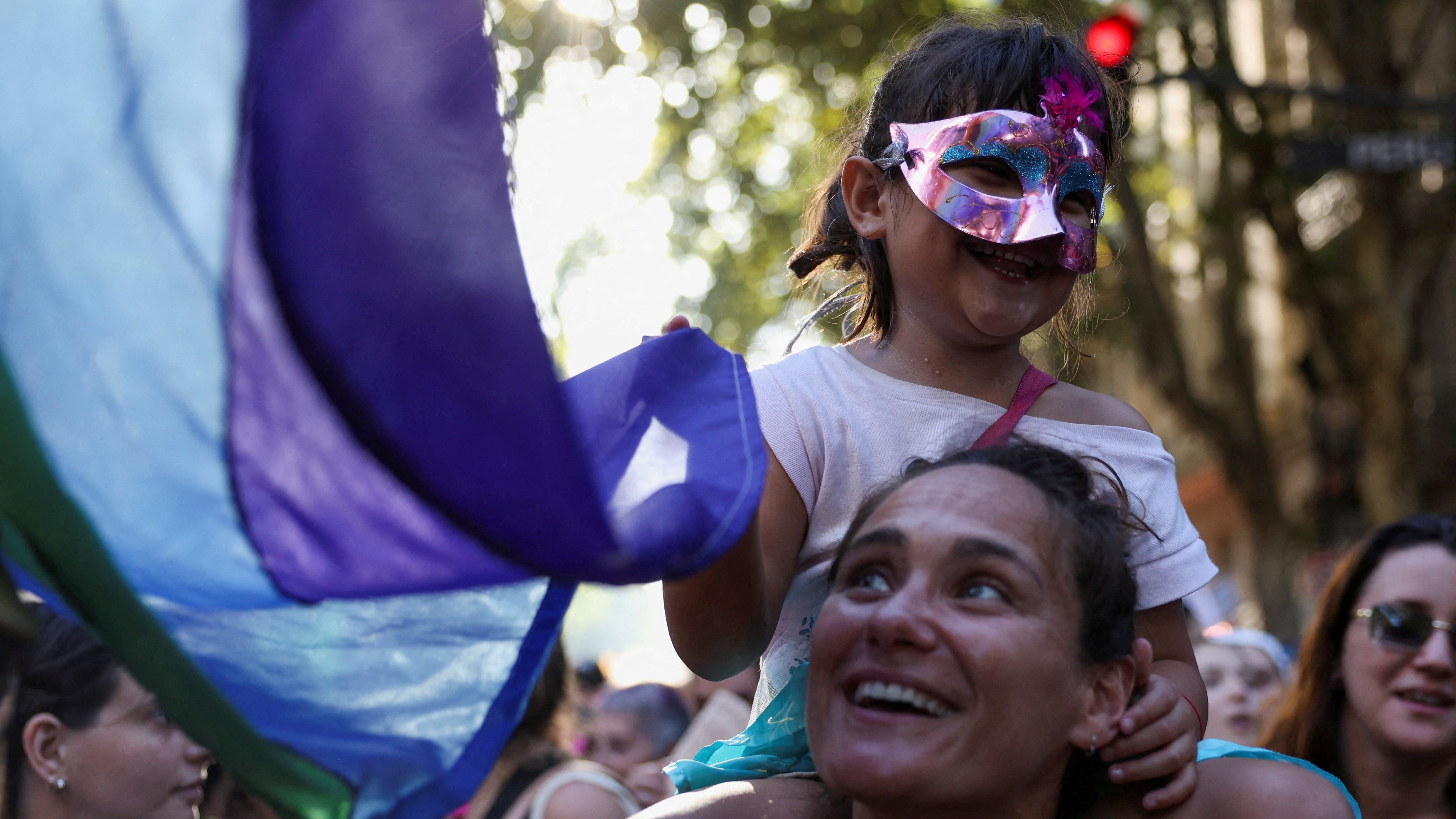 Unha muller leva unha nena nos ombreiros na marcha da capital. REUTERS/Cristina Sille