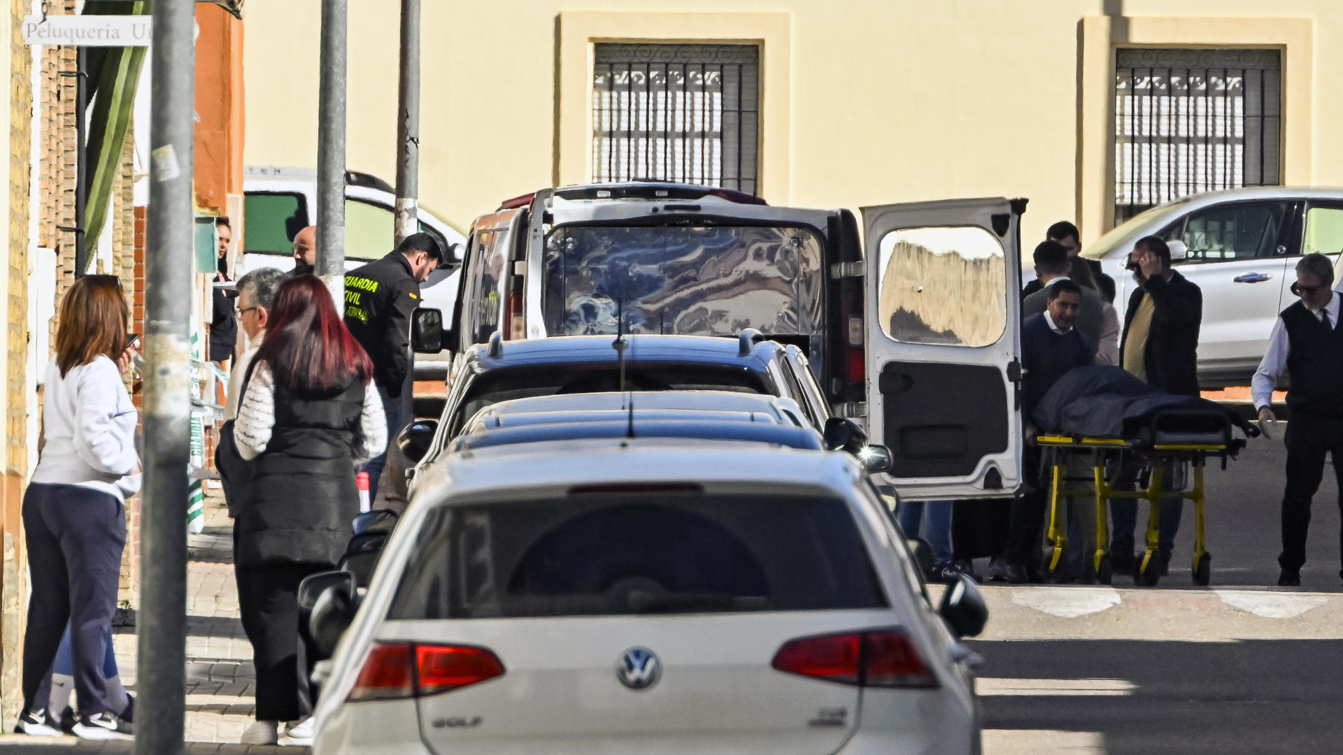 Empregados da funeraria trasladan o corpo sen vida dunha muller dunha vivenda da localidade sevillana de Brenes (EFE/ Raúl Caro)