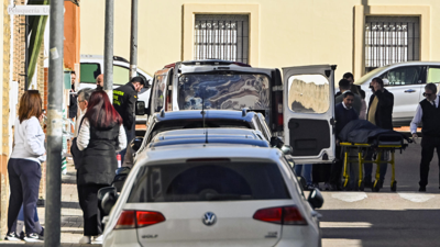 Empregados da funeraria trasladan o corpo sen vida dunha muller dunha vivenda da localidade sevillana de Brenes (EFE/ Raúl Caro)